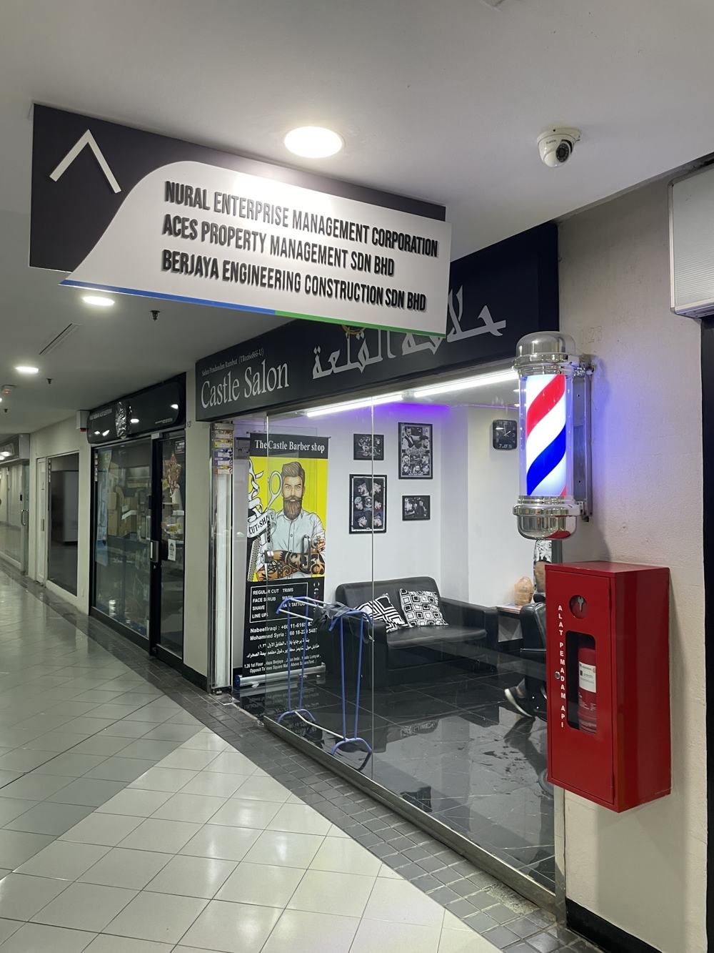 Barber pole and services banner at the entrance